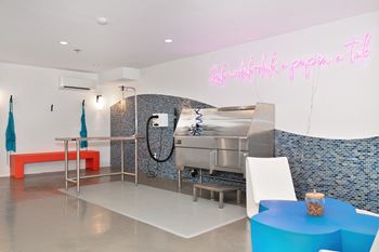 a kitchen with a grill and a table and a pink neon sign  at Track 281 Apartments, Sacramento, CA